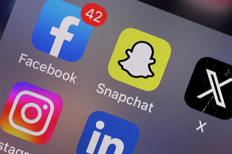 Image: A phone screen with several icons for social media apps like Facebook, Snapchat, Instagram and X.