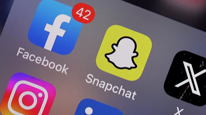 A phone screen with several icons for social media apps like Facebook, Snapchat, Instagram and X.