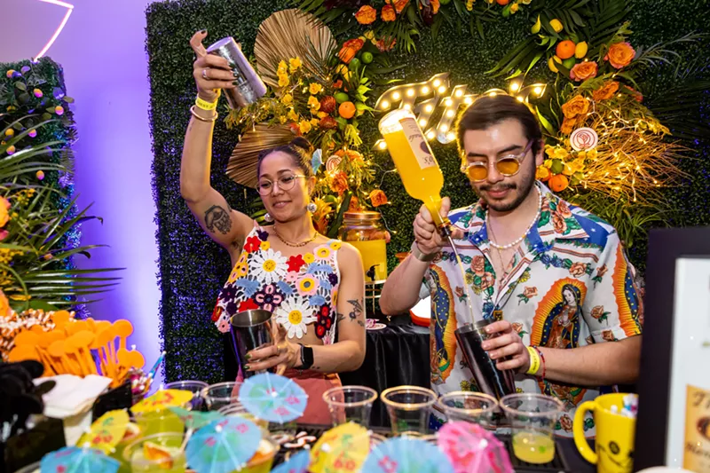 Image: Two bartenders making drinks.