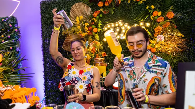 Two bartenders making drinks.