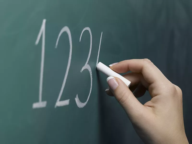Image: a hand writing 1-2-3-4 on a chalkboard