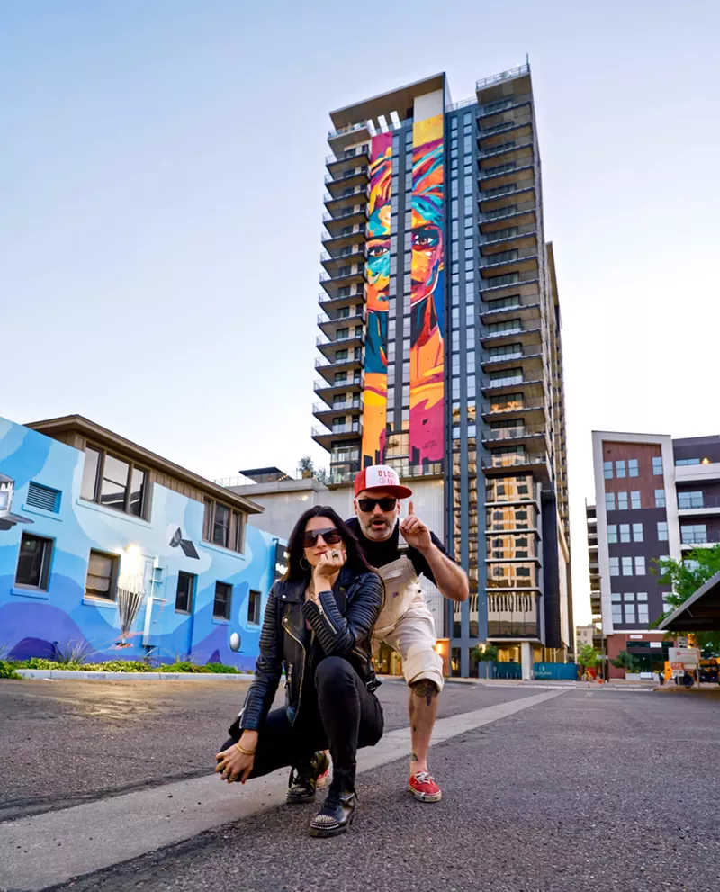 Image: Leila Parnian, left, and Daniel Lorden pose in front of "Through Her Eyes."
