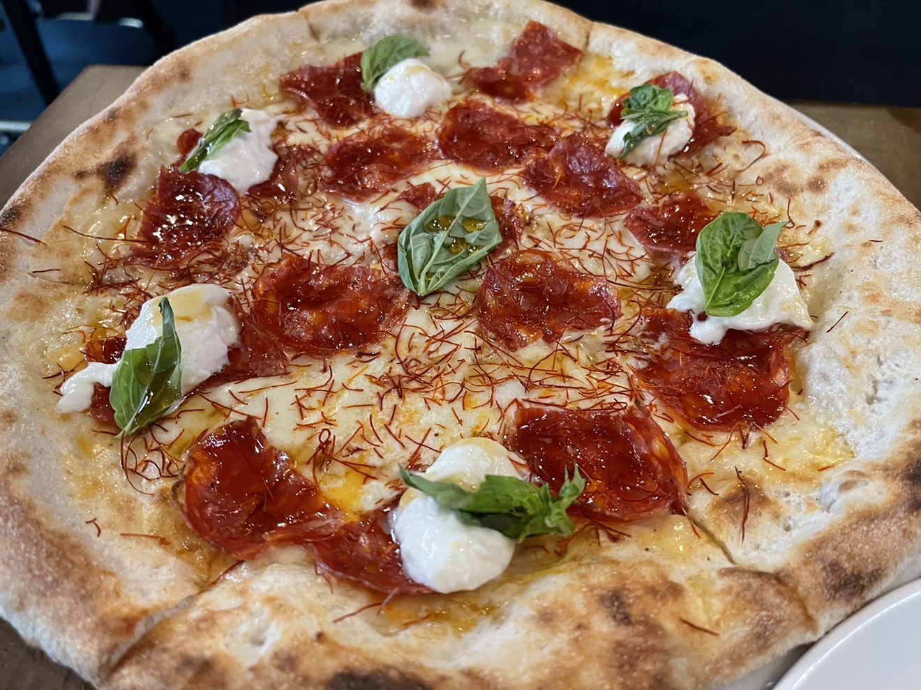 The Burratella Pizza at Pomo comes topped with chili threads and fresh basil.