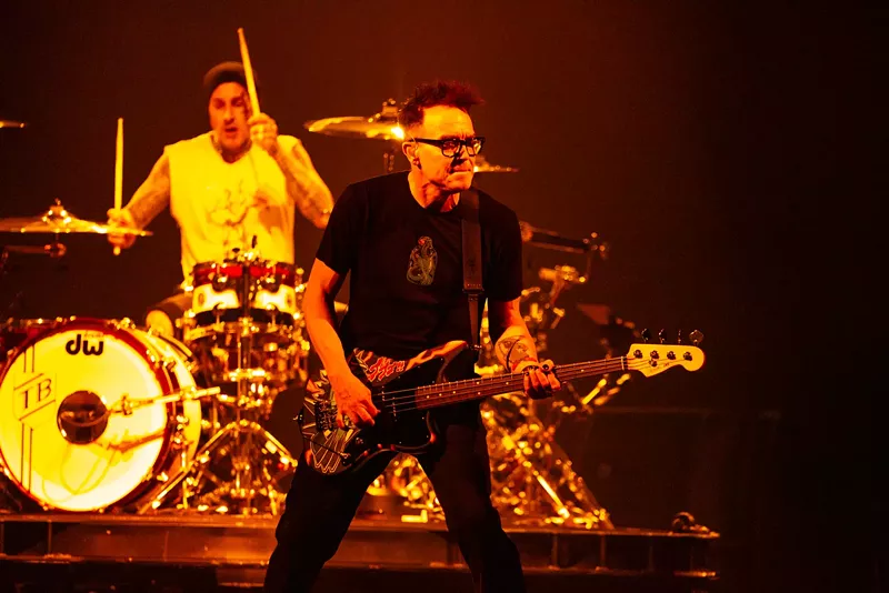 Image: A man playing bass in front of a man playing drums.