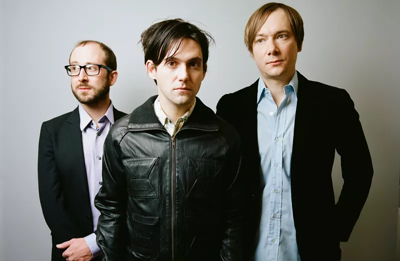 Image: Three men posing for a picture.