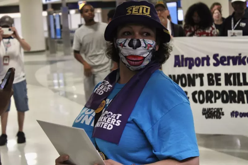 Image: A woman in a blue shirt and dia de los muertos facemask