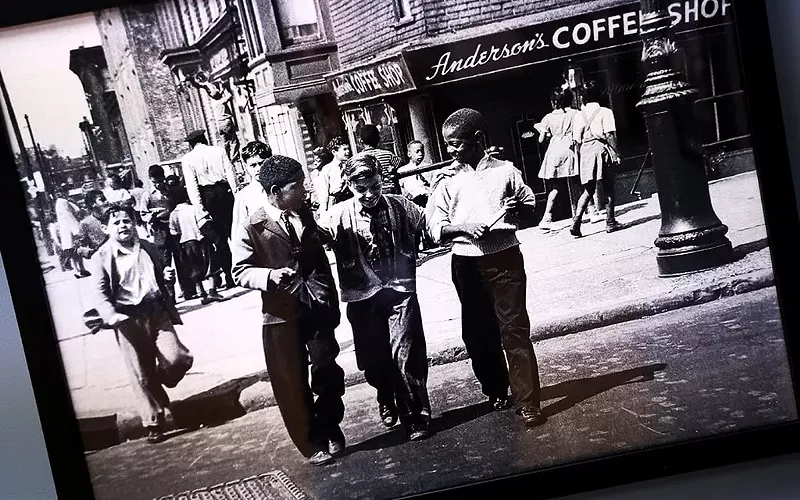 Image: A photograph from the ‘Black Folk Photography’ exhibit depicts Black and white children walking together across a street in New York City during the 1930s.
