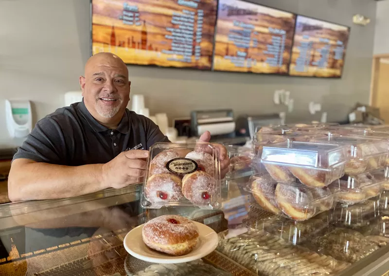 Image: Scott's Generations owner Scott Snyder holds a package of four sufganiyot.