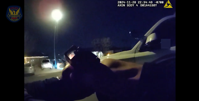 Image: body-cam footage of two hands holding a pistol