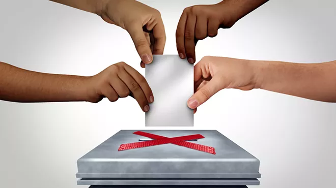 four hands trying to put a piece of paper through a slot that is blocked off with an x
