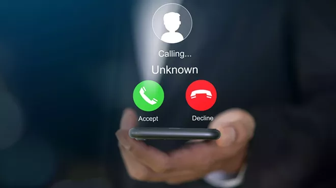 a hand holding a phone that is getting a call from an unknown number