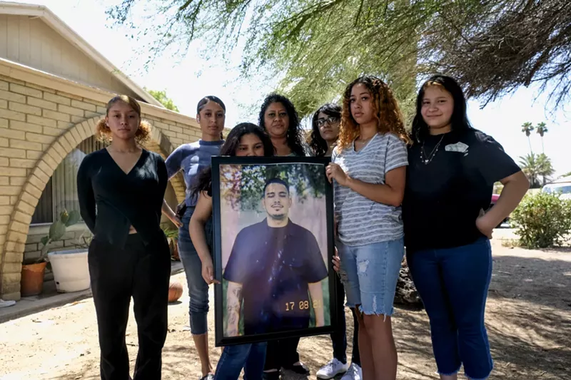 Image: Members of Juan Reynoso's family, including his wife and daughters, gather outside his mother's home in Tempe.