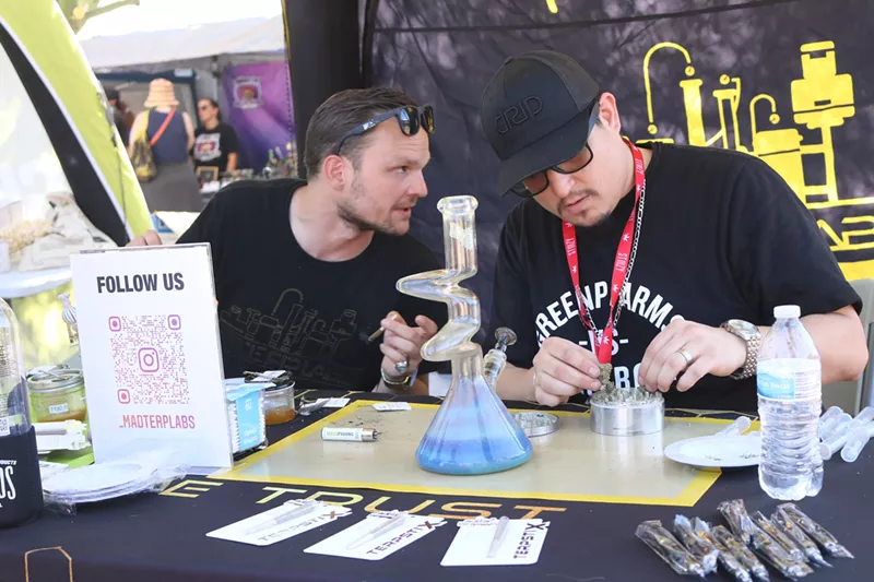 Image: Angel (right) from GreenPharms, filled the bong with Mac V2 flower for people to test at Mangja Ganja on October 2.