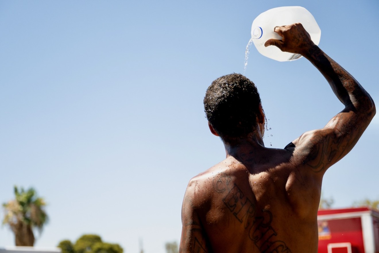A person cools off amid searing heat that reached 115 degrees on July 16. A new report issued Wednesday said heat killed a record number of people last year in Maricopa County.
