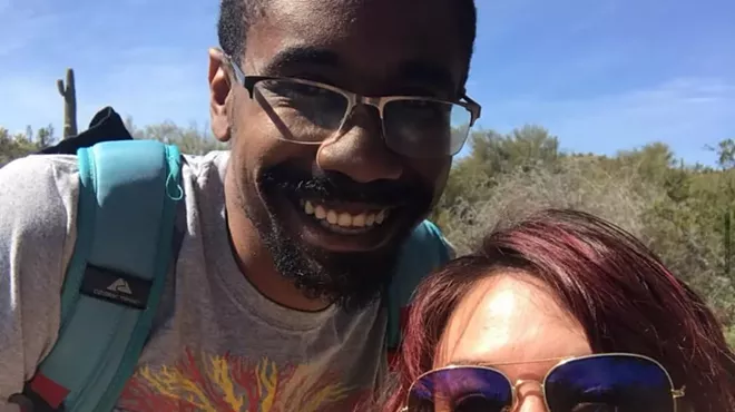 a man and woman pose for a selfie outdoors