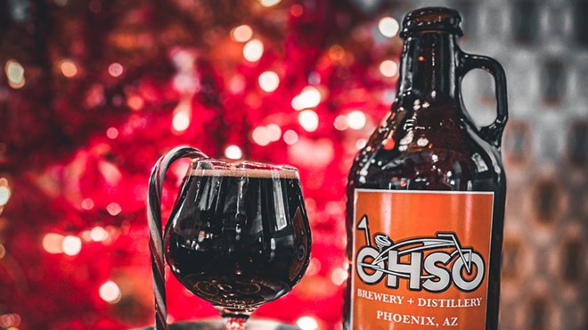 A pint of O.H.S.O. seasonal beer in front of a Christmas tree.