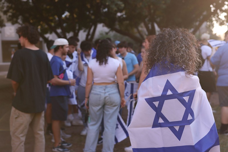 A woman drapes herself in an Israeli flag during an event on Wednesday at Arizona State University's campus in Tempe mourning people killed in the Israeli-Hamas fighting and celebrating the Jewish heritage of those at the event.