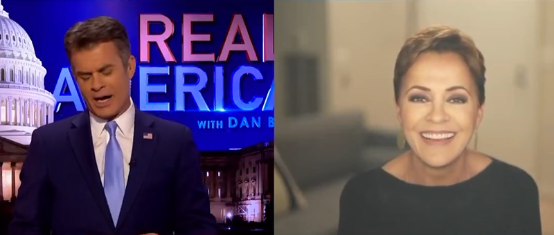 Image: kari lake smiles while on an OAN show