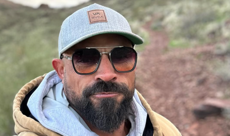 Image: a man in a hat and sunglasses outside
