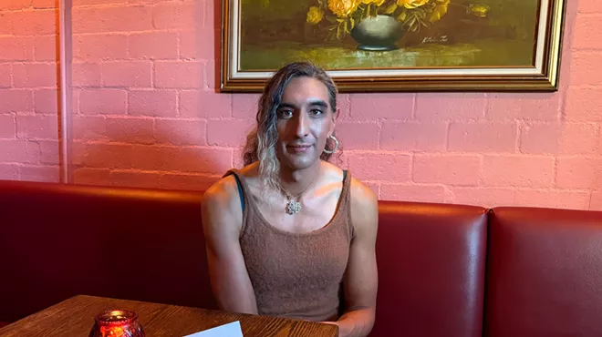 Kristen Martinez sits in a booth with a tray of two tacos.