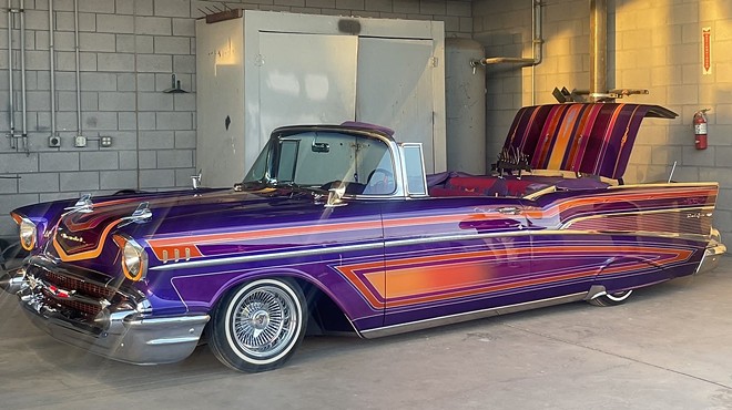 A vintage car painted purple and orange.