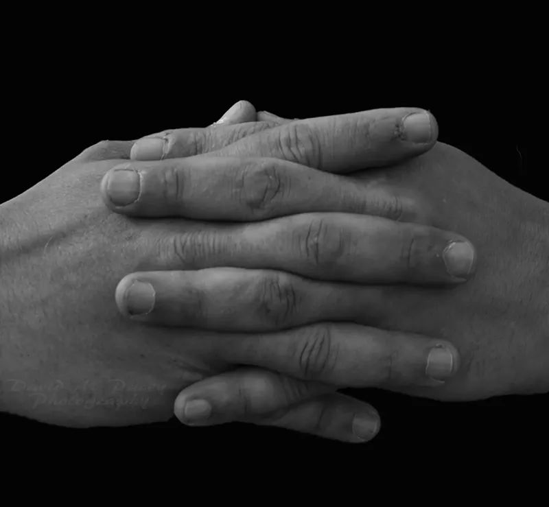 Image: A black and white photo of folded hands.