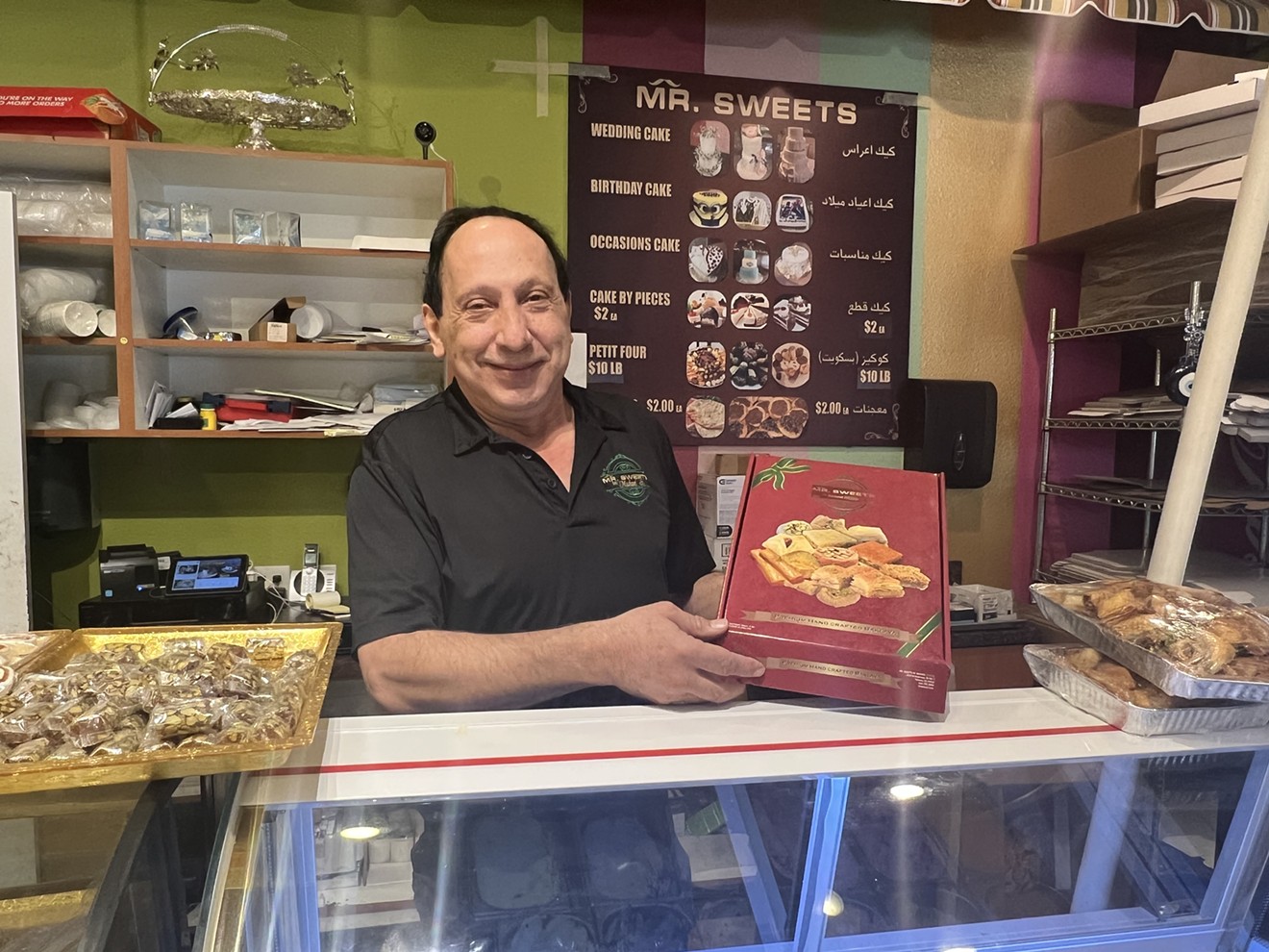 Michael Shatila, the owner of Mr. Sweets, poses with a tray of baklava.