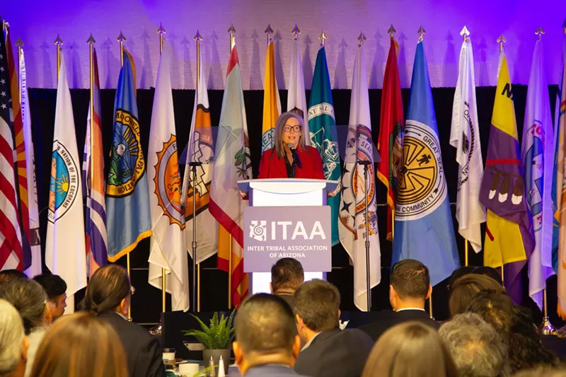 Image: A woman standing in front of a line of flags.