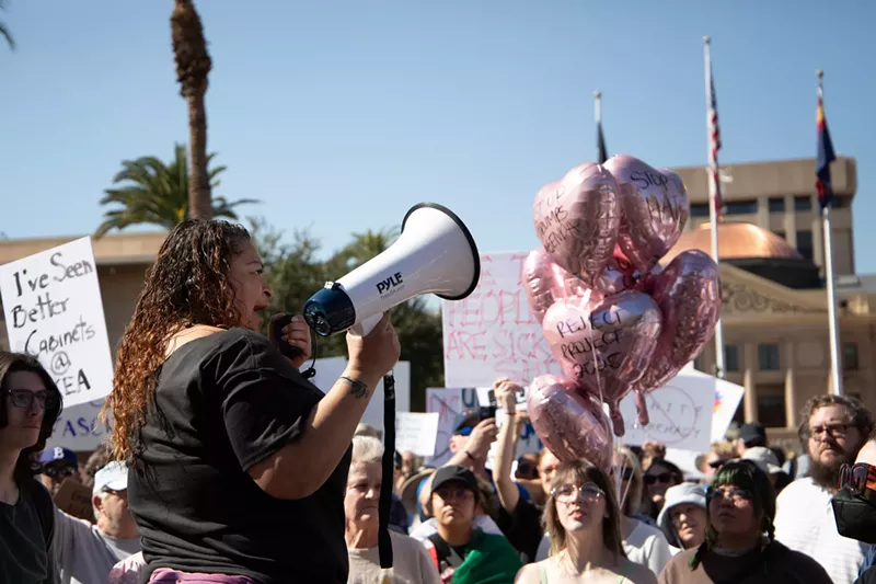 Image: a person speaks into a megaphone at a protest