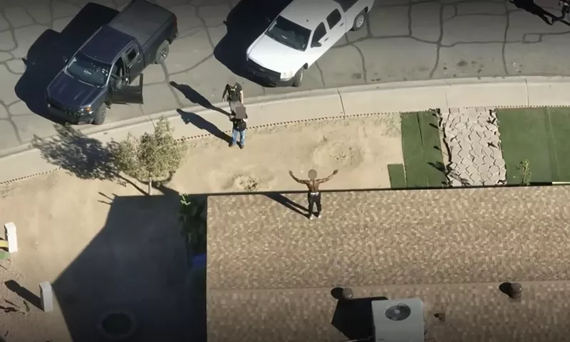 Image: Phoenix police officers aim their weapons at Turrell Clay as he stands on a rooftop with his arms raised in surrender in Maryvale on Jan. 10.