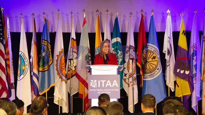 A woman standing in front of a line of flags.