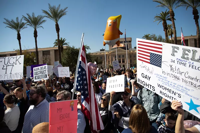 Image: protesters with an inflatable donald trump baby balloon and signs that say "stop fascism"