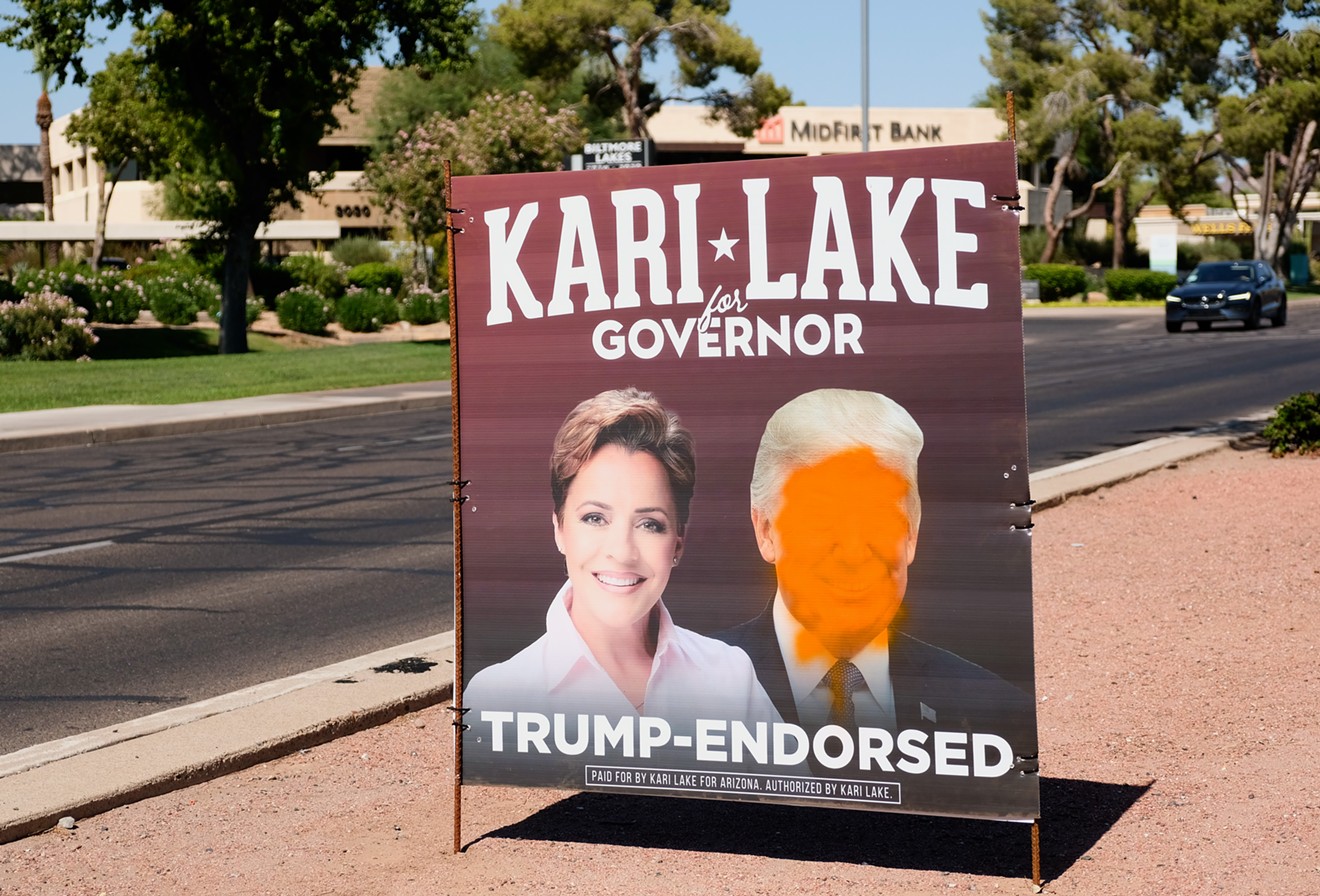 A Kari Lake sign, spraypainted, on Camelback Road in central Phoenix.