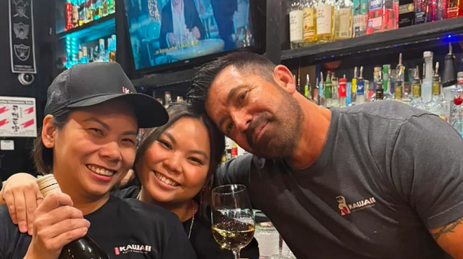 a man and two women pose for a photo in a restaurant