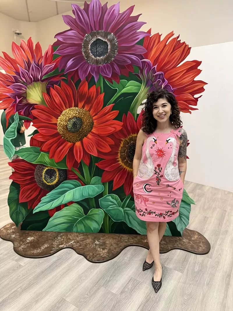 Image: Ariana Enriquez poses with one of the works in her "Con Cariño Siempre" exhibition.