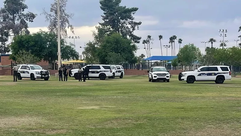 Image: Police officers and vehicles at a park.