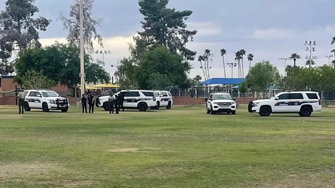 Police officers and vehicles at a park.