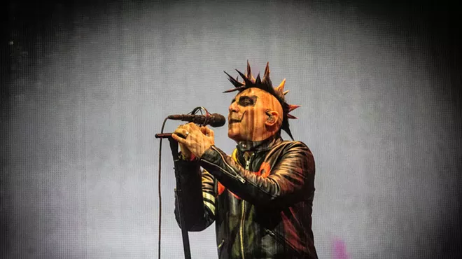 A man in makeup singing.