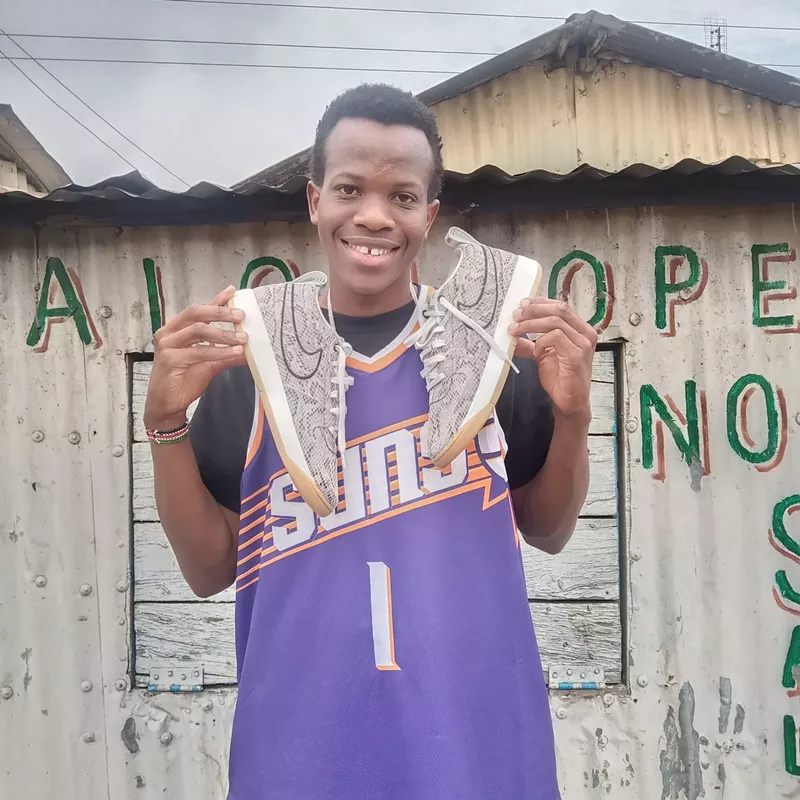 Image: Overjoyed Suns fan Hussein Siro shows off his new Book 1 Python sneakers and Booker jersey in Nairobi, Kenya, on Nov. 13 after receiving a second package from the Suns’ global fanbase.
