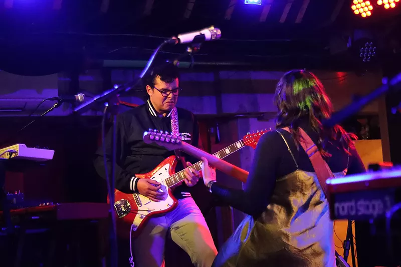 Image: Cassidy Hilgers grooves with a member of her band Hyperbella on stage.