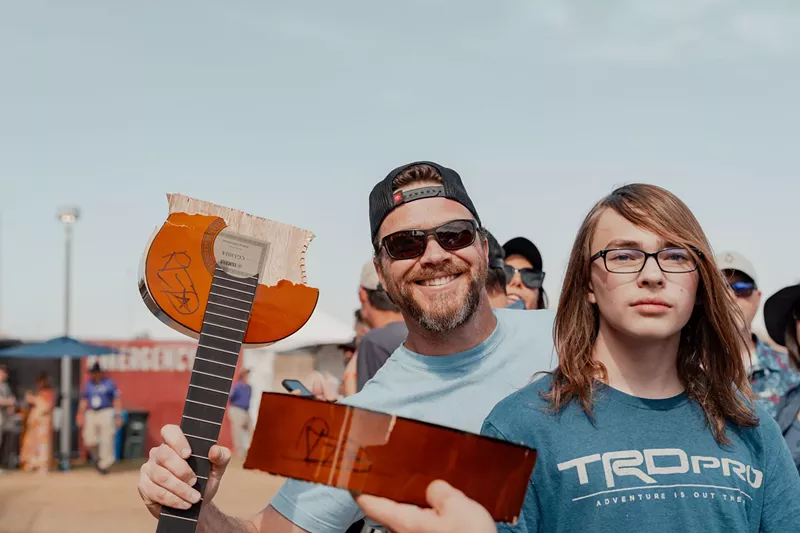 Image: A fan celebrates catching a broken guitar from a weekend performance.