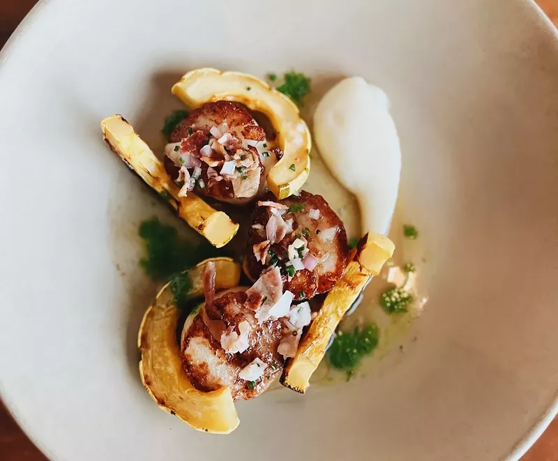 Image: Pan-seared scallops with truffle cauliflower purée, bacon vinaigrette and delicata squash is one of the elegant entrees on the menu at Commoner & Co.