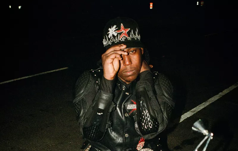 Image: A young Black man posing on a motorcycle.