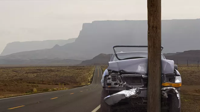 a car crashed into a pole on a remote desert road
