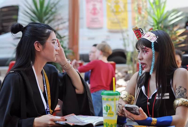 Image: A pair of Phoenix Fan Fusion attendees have a chat outside the convention center.