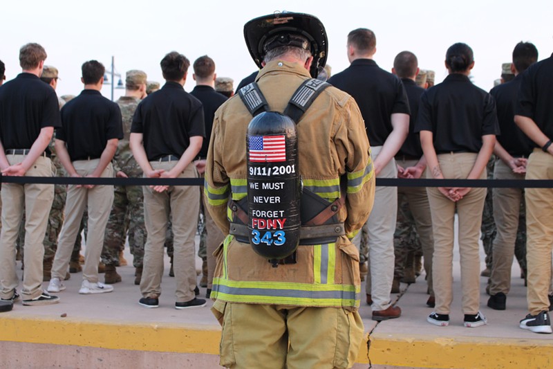 A firefighter bows his head during a 9/11 memorial at the Tempe Healing Field on Sept. 11, 2024.