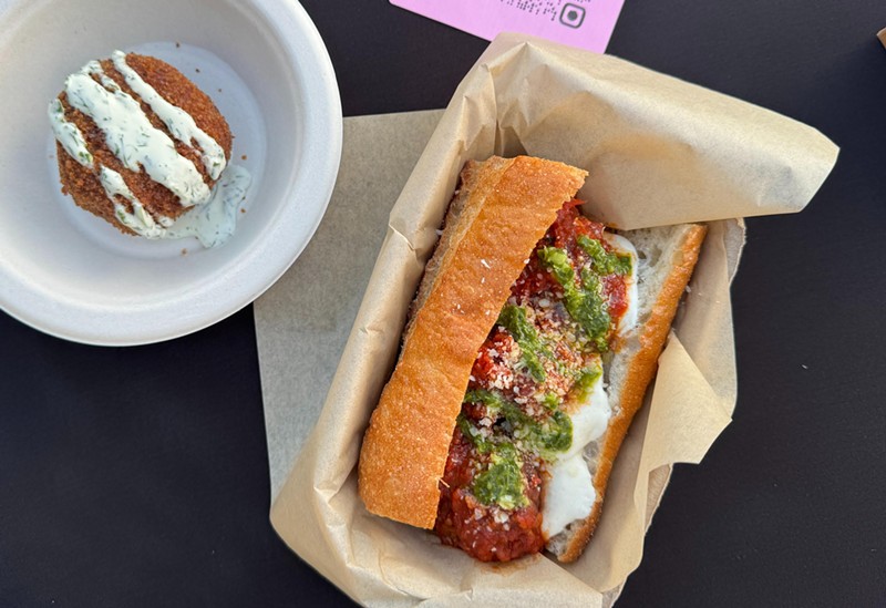 A Meatball Hero and a baseball-sized arancini from Sorelle. The hero is made with tender meatballs stewed in red sauce and topped with mozzarella and pesto.