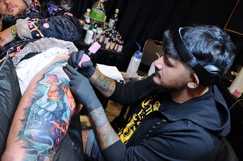 Image: A tattoo artist creating a tattoo.