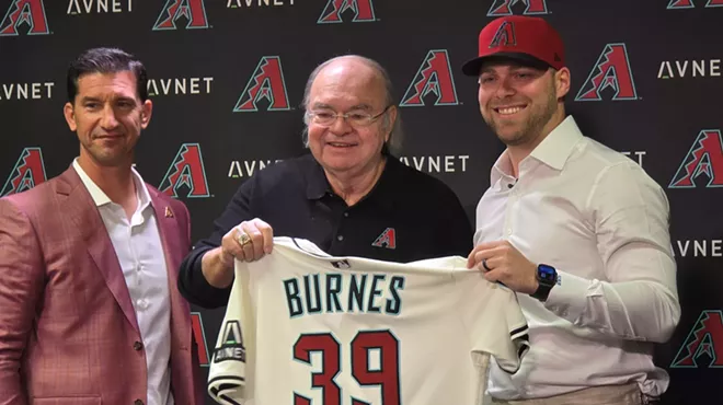 mike hazen and ken kendrick hand a diamondbacks jersey to corbin burnes