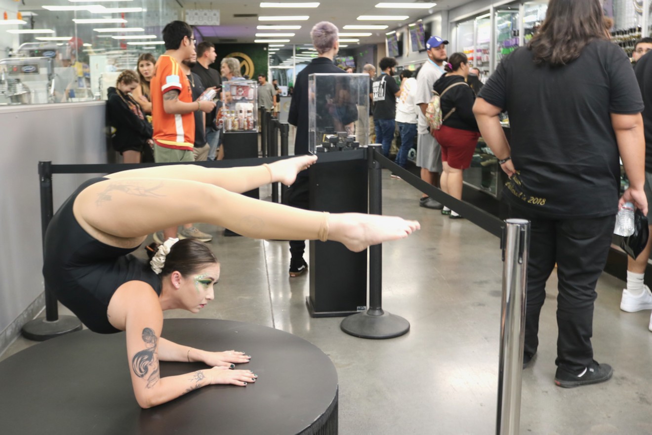 Contortionist Alexis Bohl greeted people as they waited in line inside the Mint's showroom as the dispensary celebrated its first night of 24-hour operations.